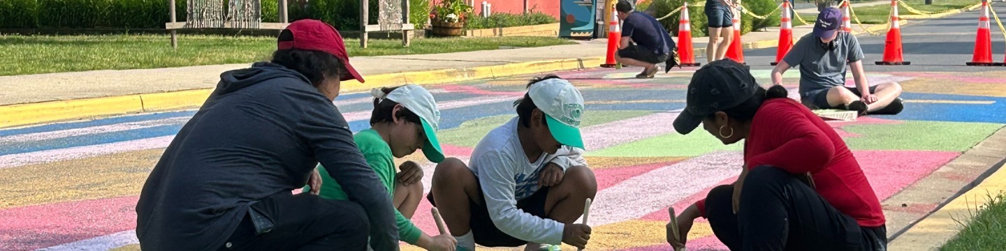Community members painting a road