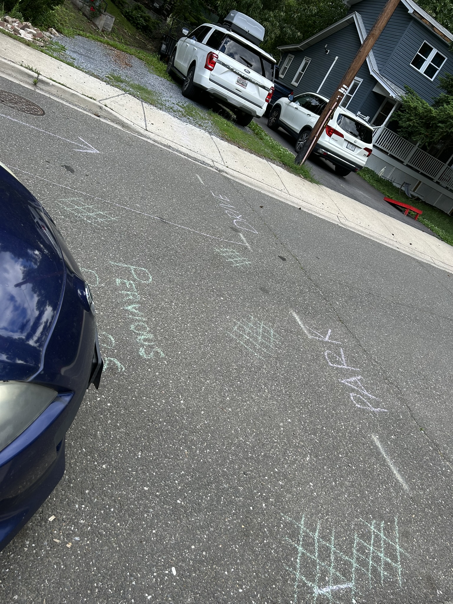 Sidewalk chalk on Kennedy Street demonstrates park lanes with pervious paving vs. asphalt drive lanes